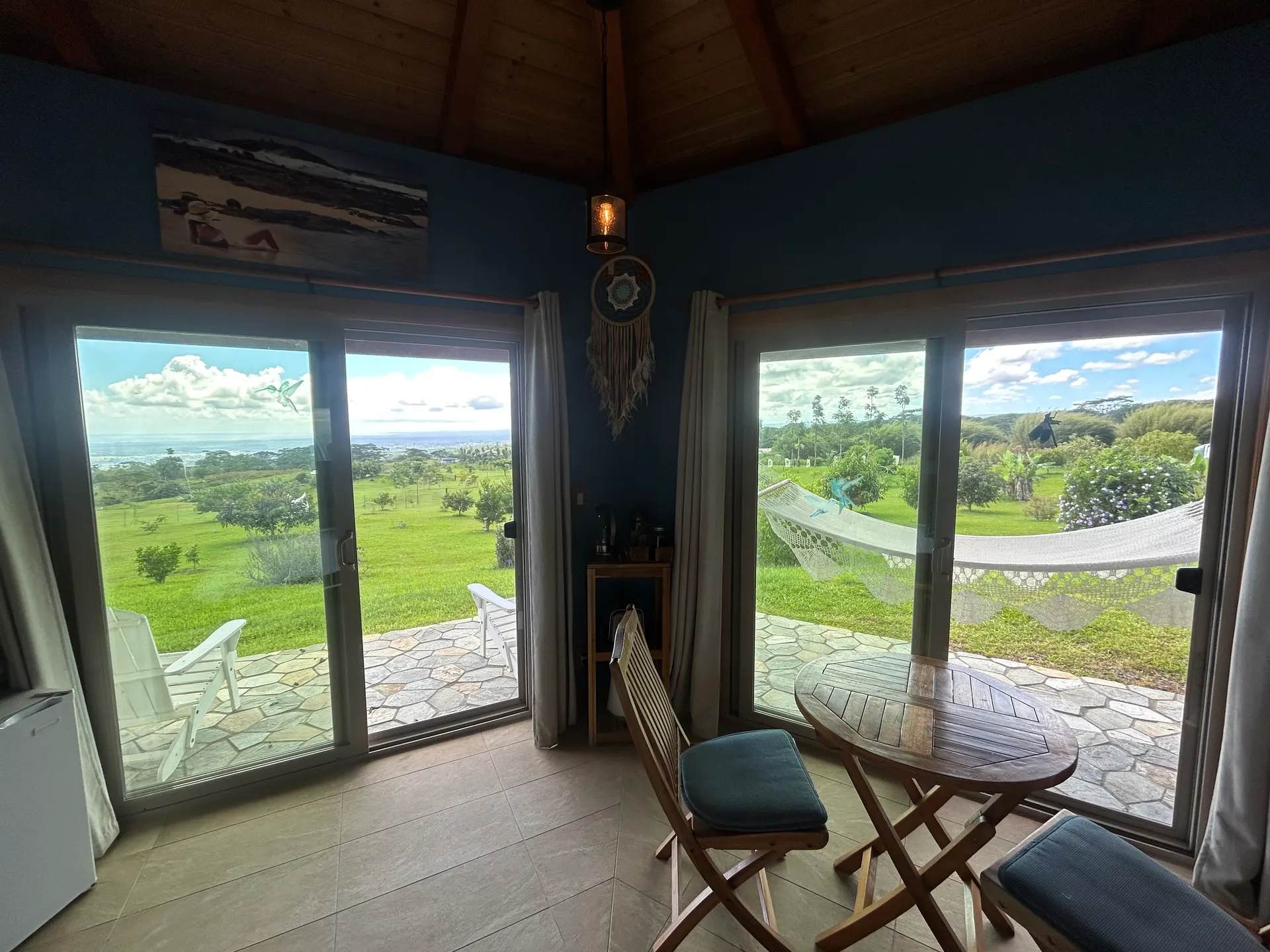 Sliding glass doors and a bistro table looking out over the young forest toward the ocean